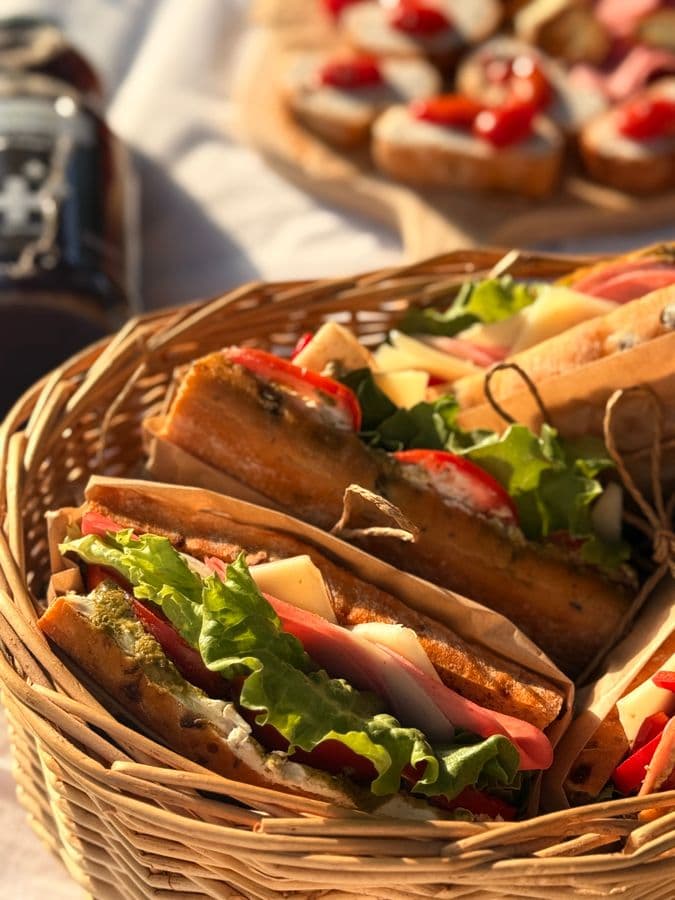 Sandwiches garnis de jambon, fromage et crudités, emballés dans du papier kraft